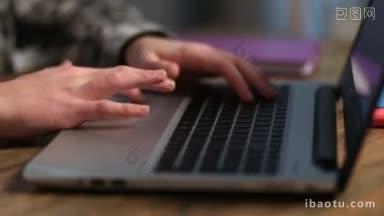 特写男学生的手触摸触摸屏上的电脑和打字，同时做作业在家里年轻的潮人工作